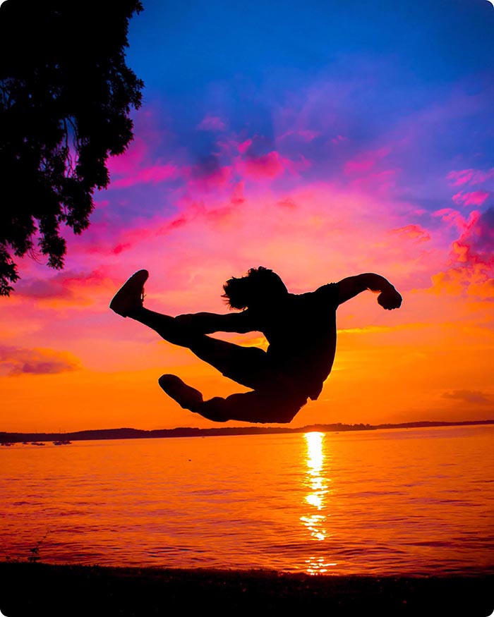 Modelo de Jack Kwan saltando en el aire contra una puesta de sol